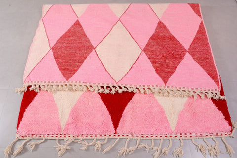 Front view of the pink Beni Ourain rug with a diamond pattern set in a studio environment.