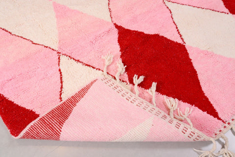 Detail close-up of the pink diamond design rug showcasing the fringe edges.