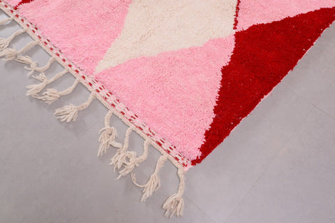 Detail close-up of the pink Beni Ourain rug with a diamond design on a studio background.