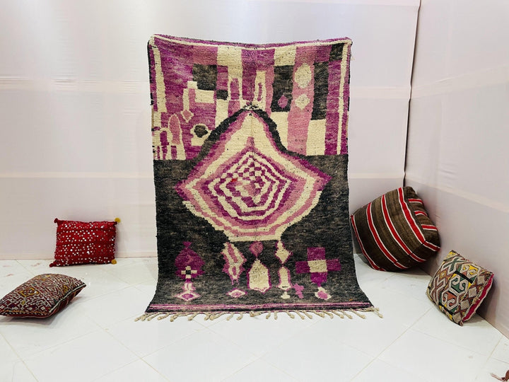 Lifestyle shot of a purple Moroccan Boujaad rug with tribal patterns on a white background.