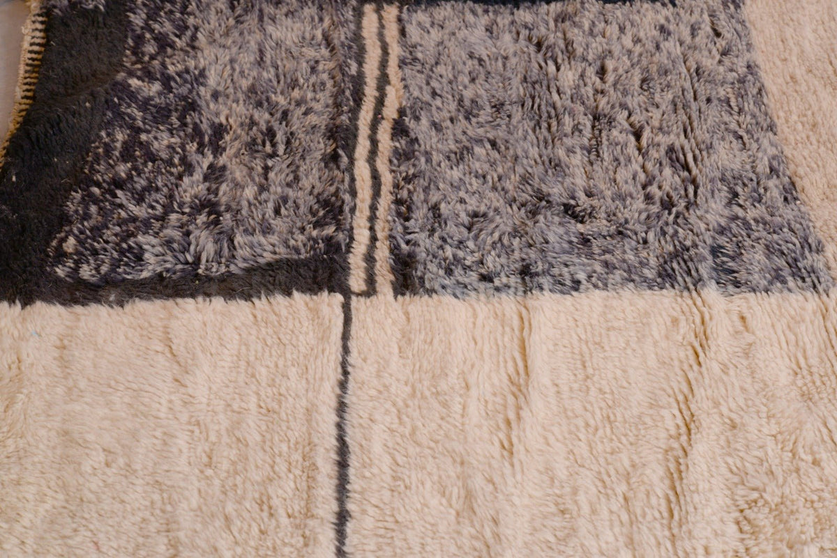 Close-up of the intricate design and fringe edges on the black and beige Tizi N'Test rug.