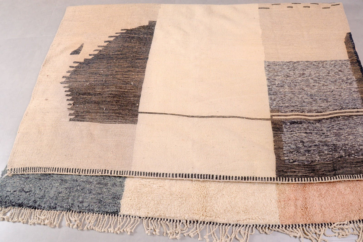 Detail view of the geometric design and textured patterns on the beige, gray, and brown rug.