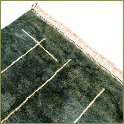 Close-up detail of a green Moroccan rug showcasing an intricate pattern and soft texture.
