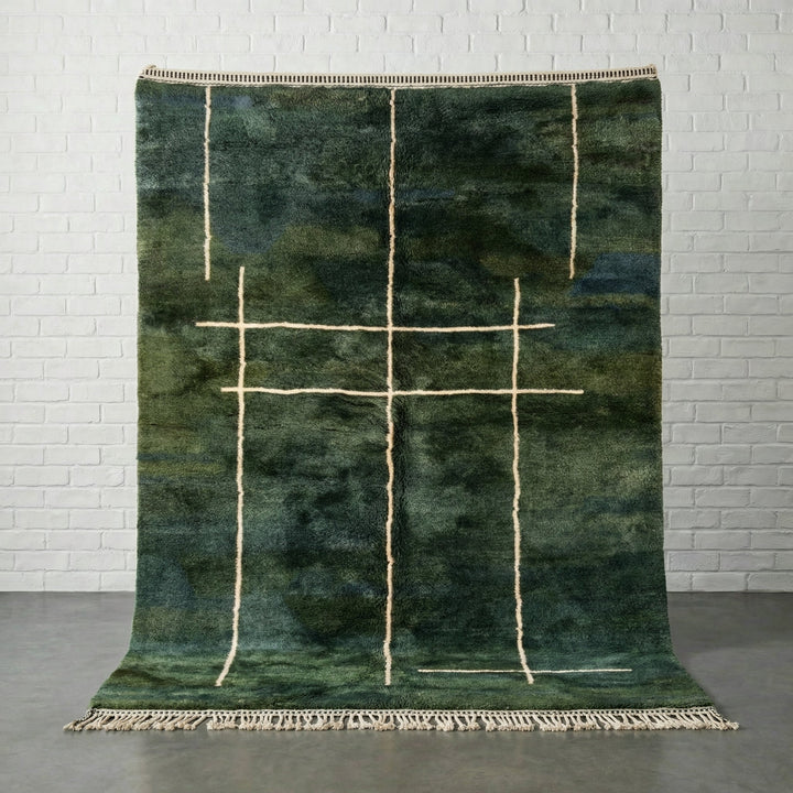 Front view of a green Moroccan rug featuring a geometric pattern and fringe edges.