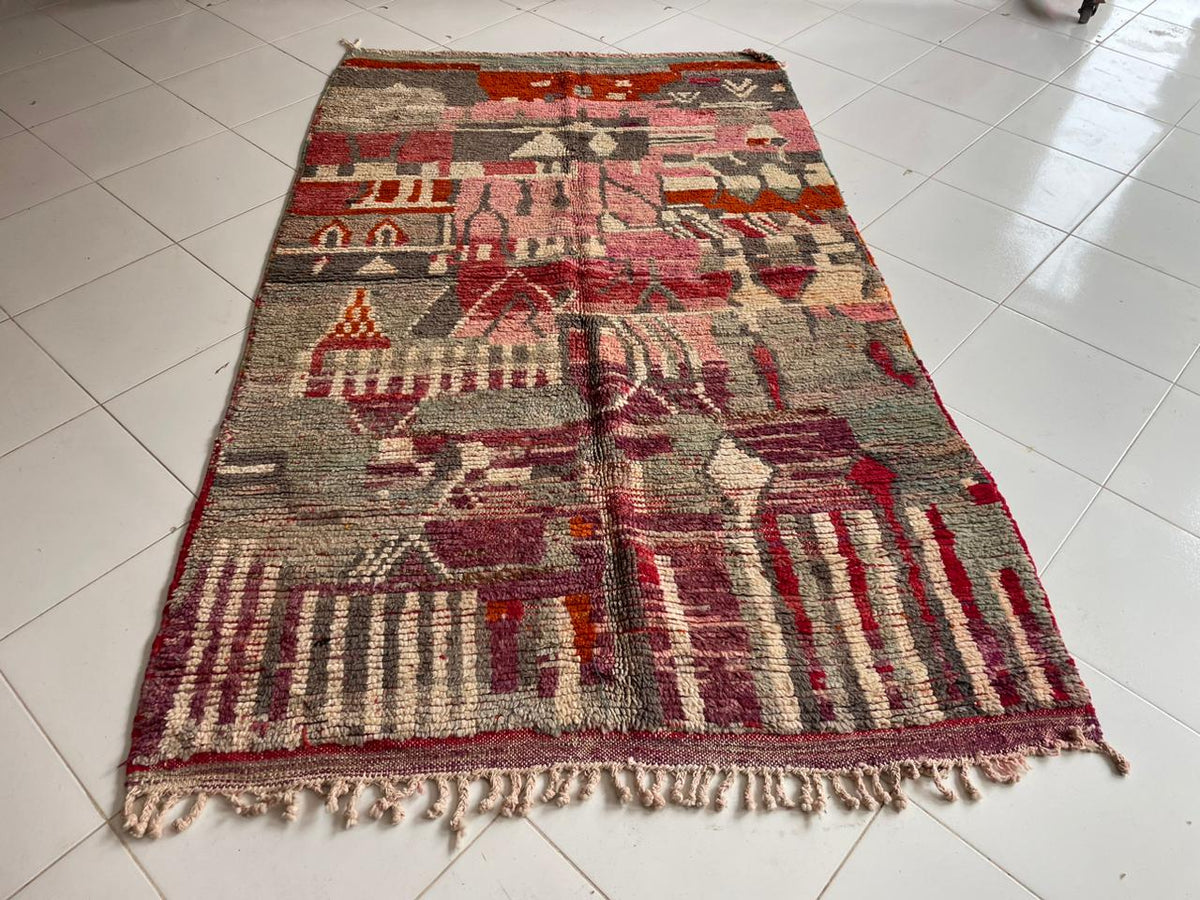 Front view of a vintage Moroccan rug showcasing tribal patterns in red, beige, and gray.