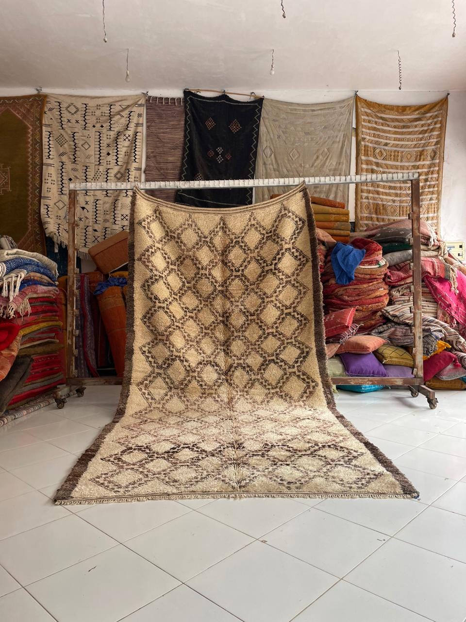 Lifestyle shot of a beige and brown geometric Moroccan rug in a living room setting.