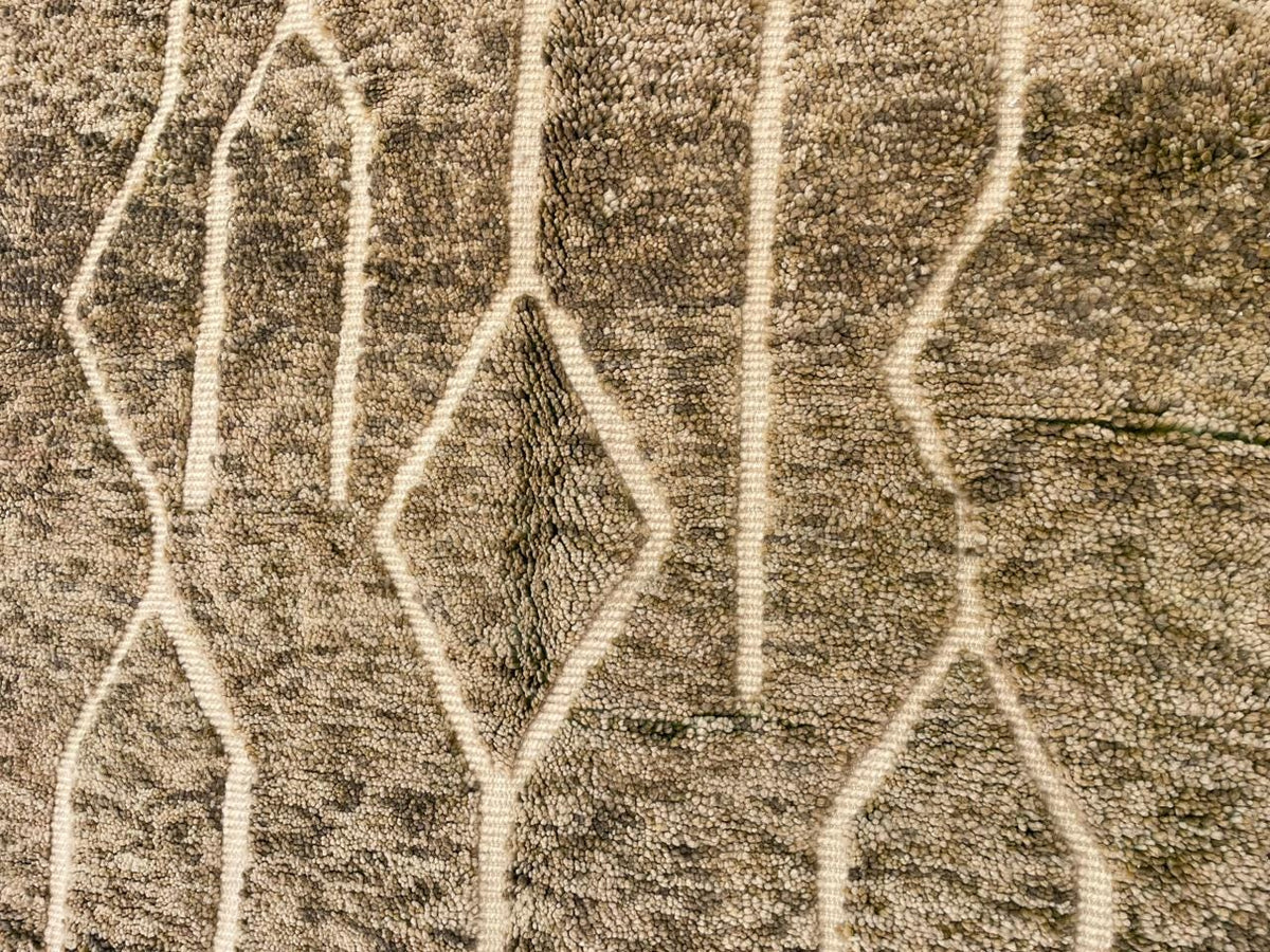 Close-up detail of the textured surface of a vintage Moroccan rug with geometric patterns.