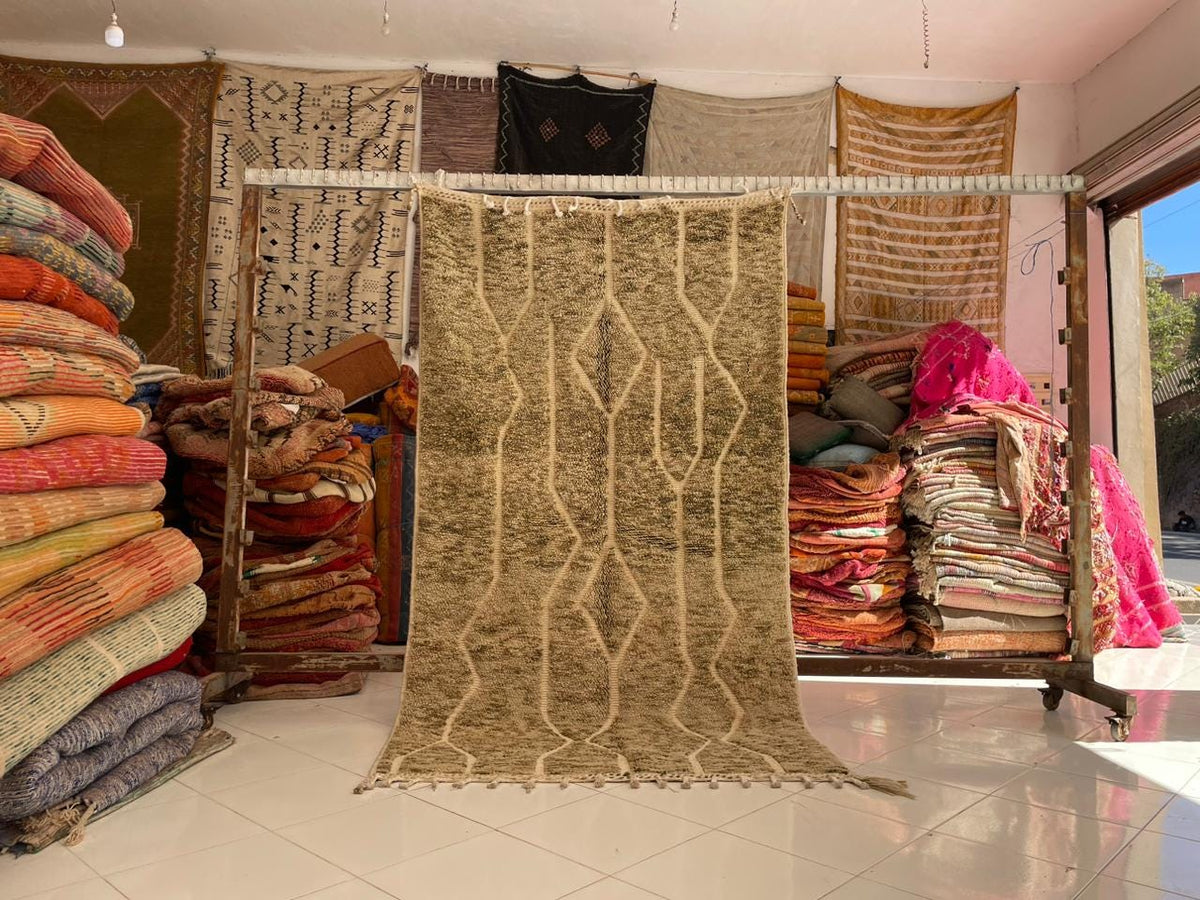 Lifestyle view of a handcrafted wool rug in a variety of colors including beige, brown, pink, and orange.