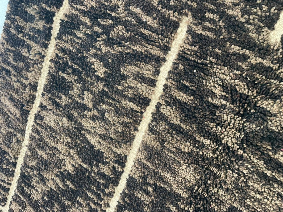 Detail close-up of a vintage Moroccan rug in black and cream colors.