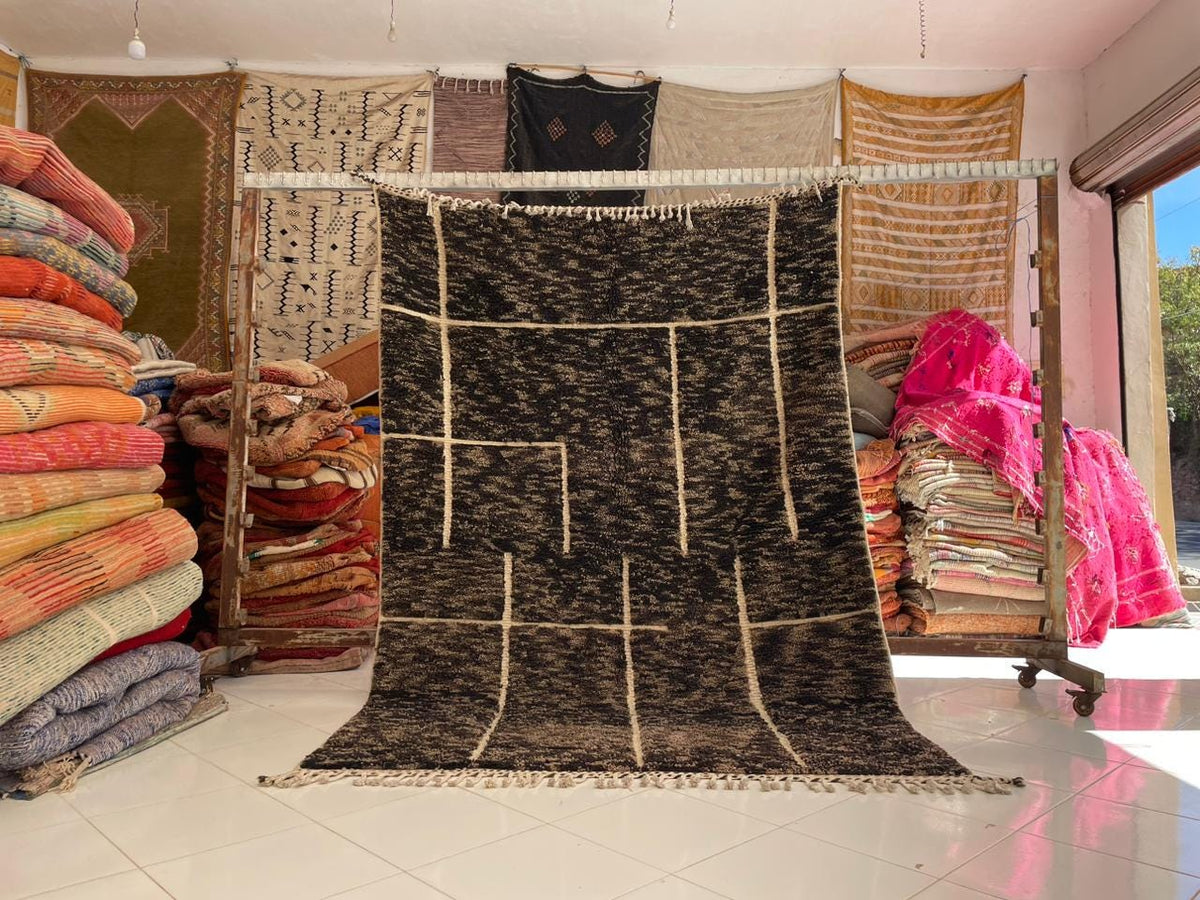 Lifestyle shot displaying a vintage Moroccan rug among various rugs in a natural setting.