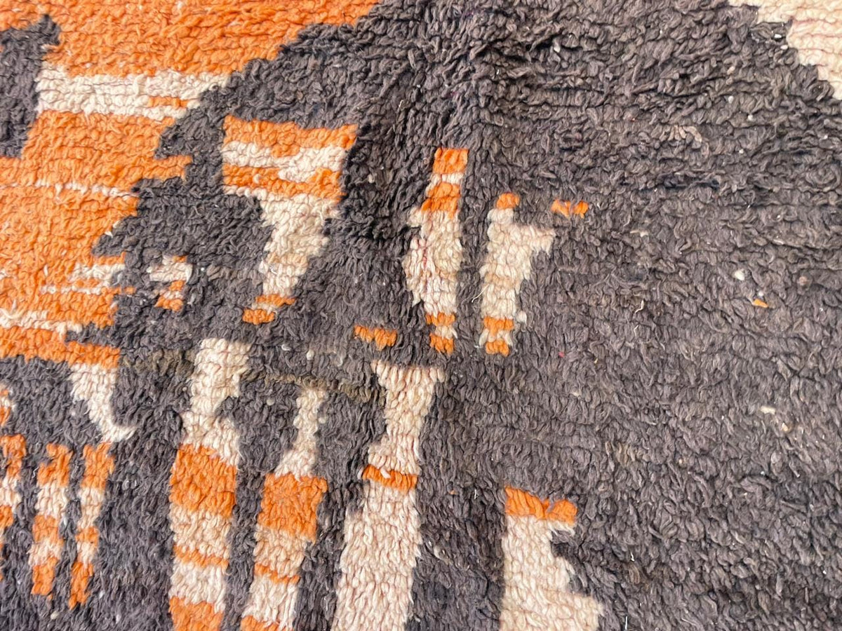 Close-up of a vintage Moroccan rug featuring an abstract design and textured pattern.