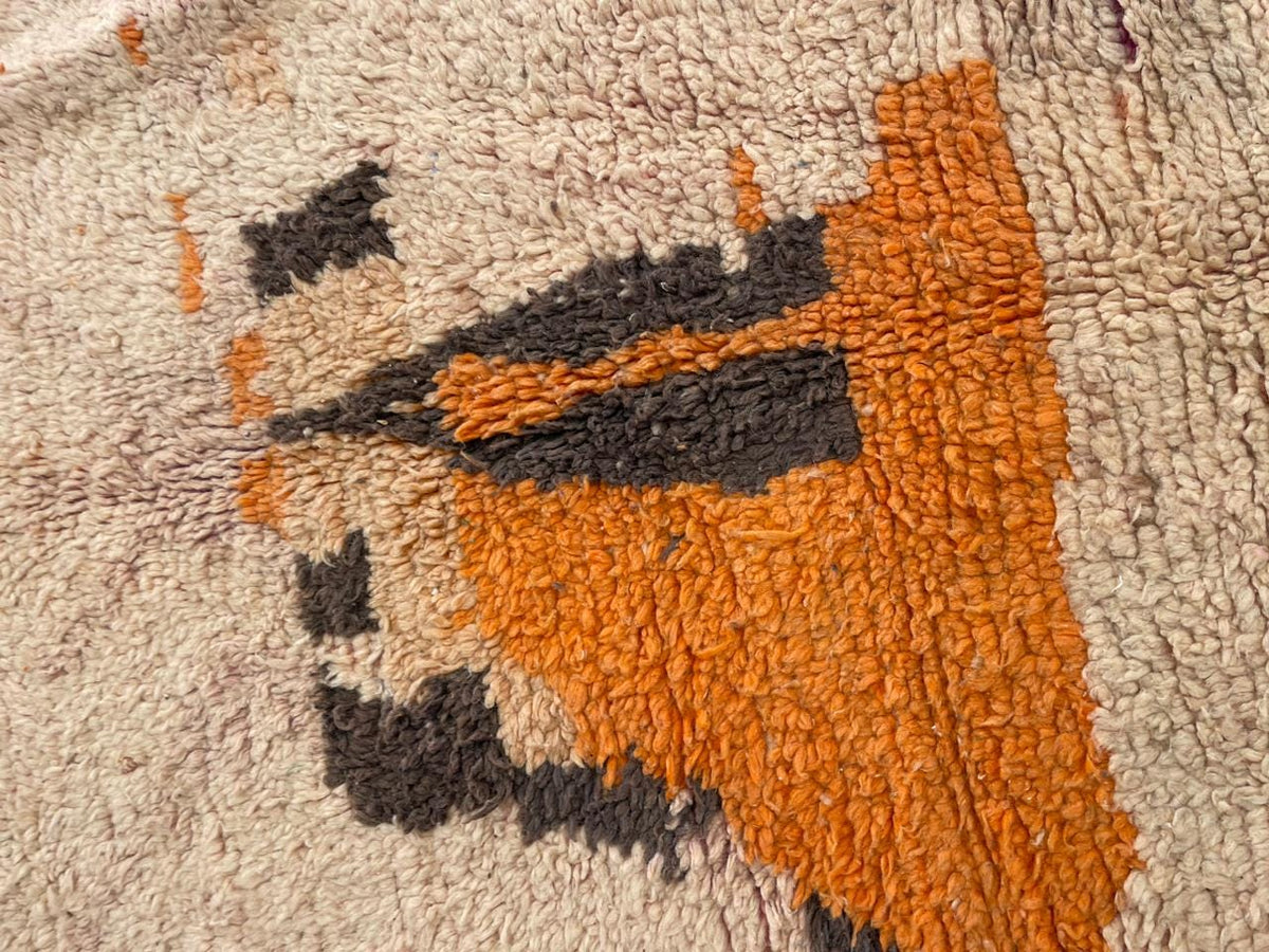 Close-up detail of a vintage Moroccan rug with a textured pattern and abstract design.