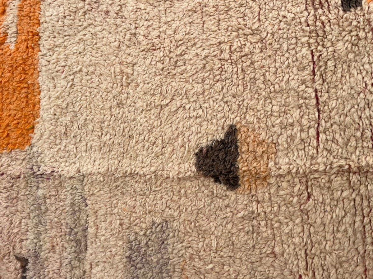 Close-up detail of a vintage Moroccan rug displaying an abstract design with a textured surface.