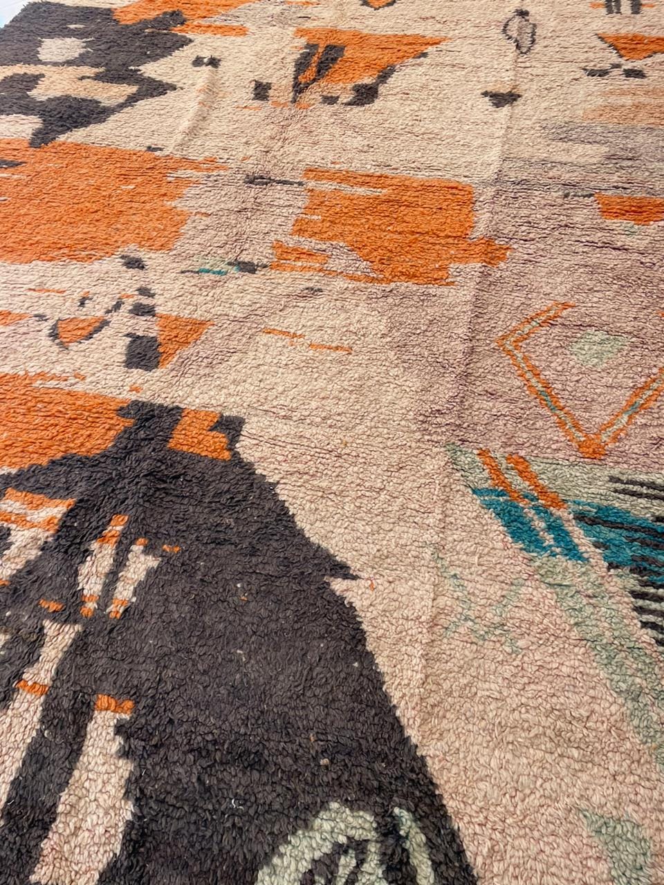 Close-up of a vintage Moroccan rug displaying a colorful design and textured fabric.
