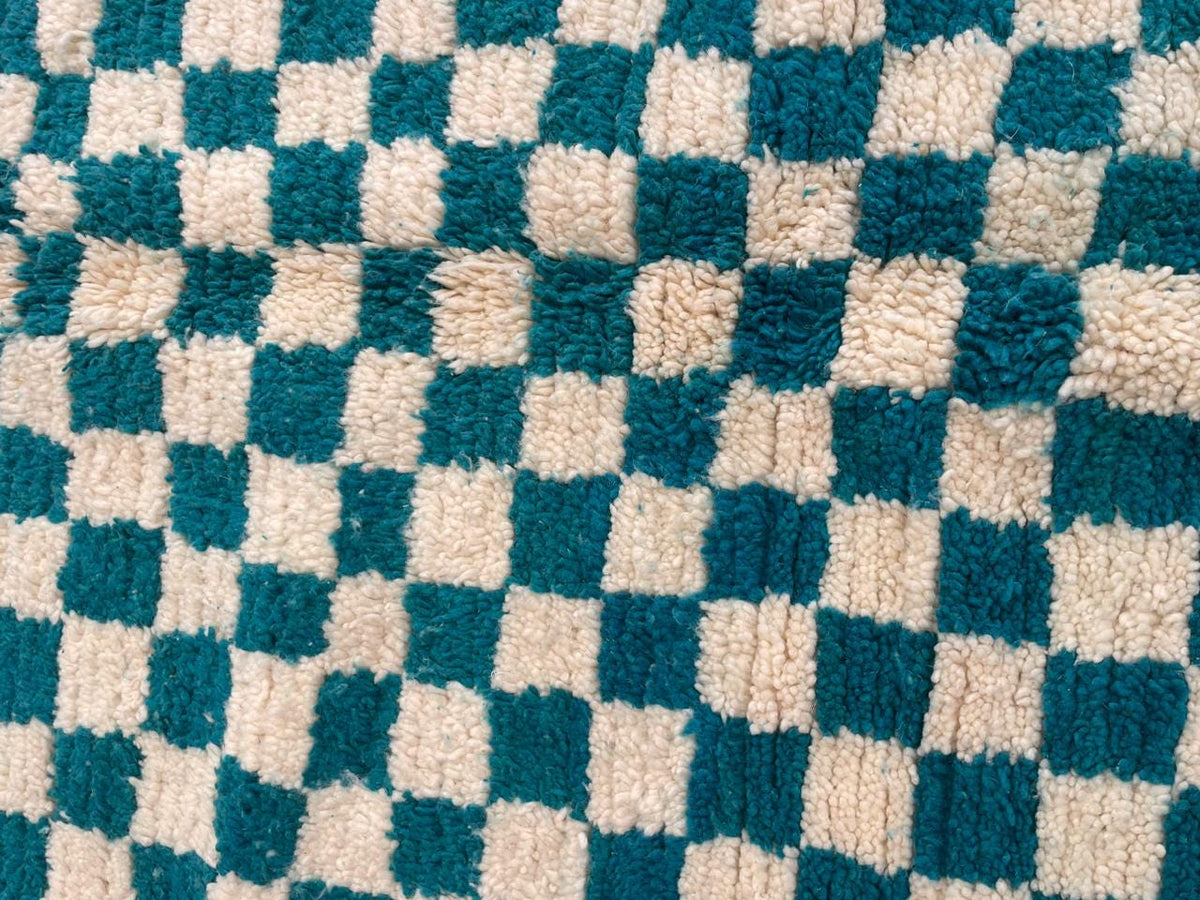 Front view of a checkered turquoise Moroccan rug showcasing its design.
