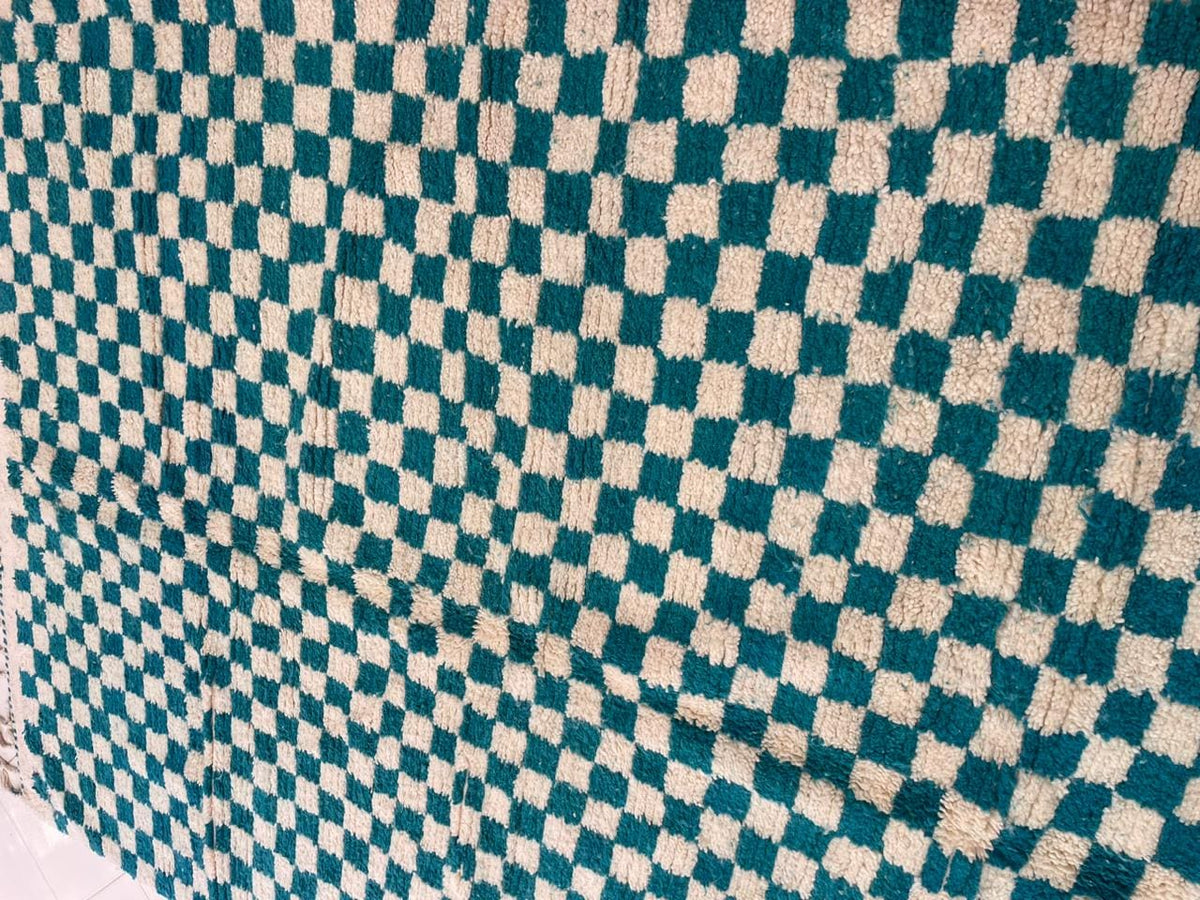 Close-up detail of the checkered pattern on a turquoise rug.