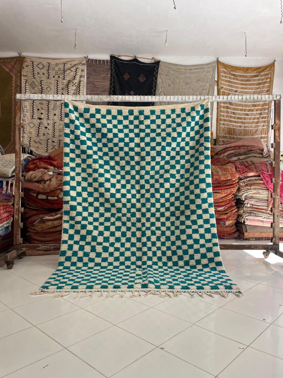 Lifestyle shot of a checkered turquoise rug in a living room setting.