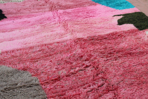 Detail shot of a colorful patterned Moroccan rug in pink and gray tones.