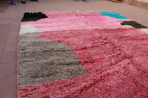 Detail close-up of a pink and black geometric Moroccan rug with a textured surface.