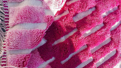 Detail shot of a pink Moroccan rug with a patterned design and soft texture.