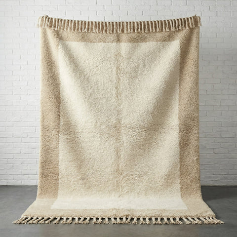 Front view of the cream and taupe handwoven Beni Ourain rug with fringe edges.