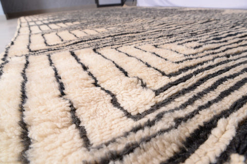 Close-up view of the intricate patterns on the black and beige Moroccan Mrirt rug.