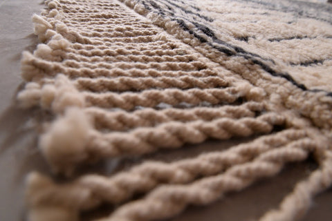 Detail shot of the wavy lines and soft texture of the black and beige Moroccan Mrirt rug.