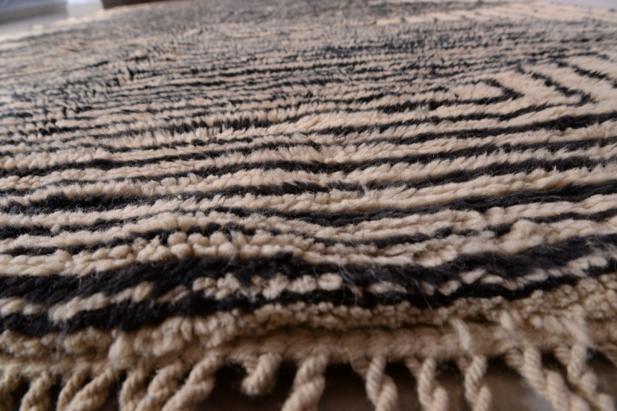 Close-up of the layered patterns and textured surface of the black and beige Moroccan Mrirt rug.