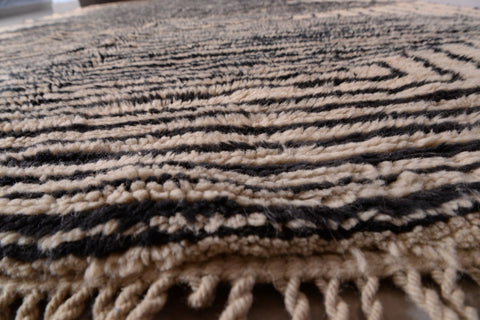 Close-up of the layered patterns and textured surface of the black and beige Moroccan Mrirt rug.