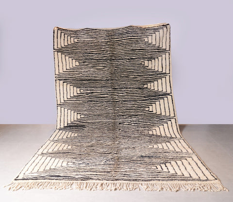 Lifestyle shot of the black and beige Moroccan Mrirt rug with intricate patterns.