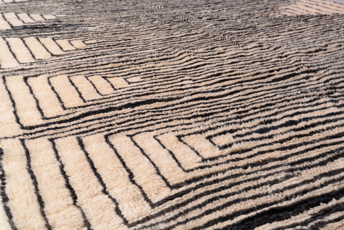 Detail shot of the layered design and textured surface of the black and beige Moroccan Mrirt rug.