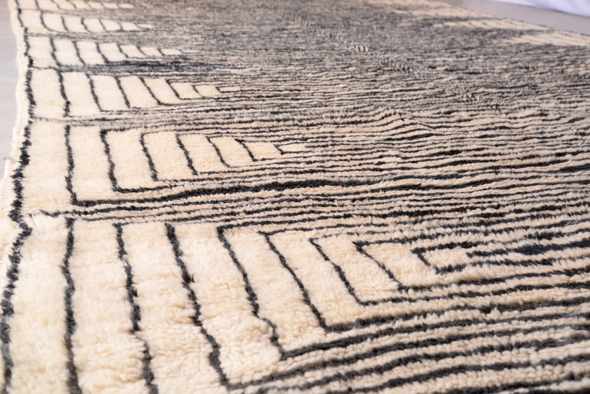 Close-up of the textured surface of the black and beige Moroccan Mrirt rug with a striped pattern.