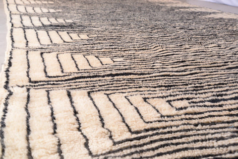 Close-up of the textured surface of the black and beige Moroccan Mrirt rug with a striped pattern.