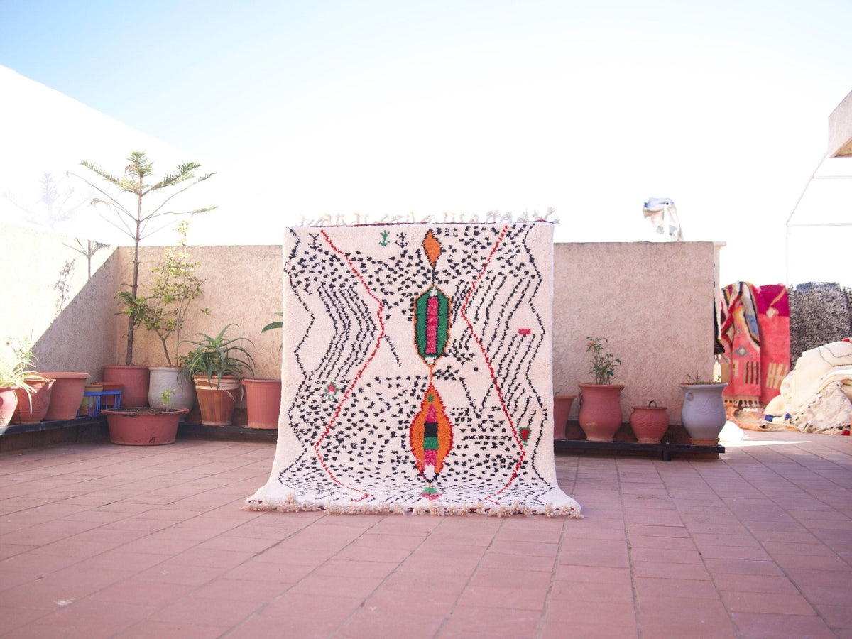 Lifestyle shot of a multicolor Moroccan rug featuring geometric patterns in a natural setting.