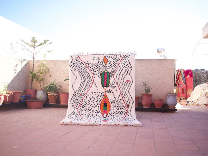 Lifestyle shot of a multicolor Moroccan rug featuring geometric patterns in a natural setting.