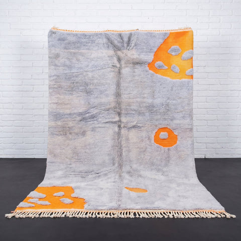 Front view of a light blue Moroccan rug with fringe edges against a white background
