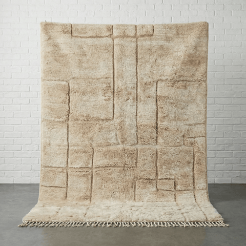 Light brown Moroccan rug with a textured pattern in a studio setting.