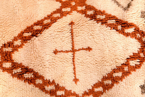 Close-up of the diamond shape motif on the orange Moroccan rug with a handcrafted look.