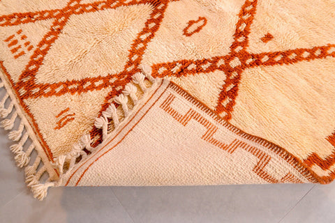 Corner detail of the orange Moroccan rug highlighting intricate patterns and woven texture.