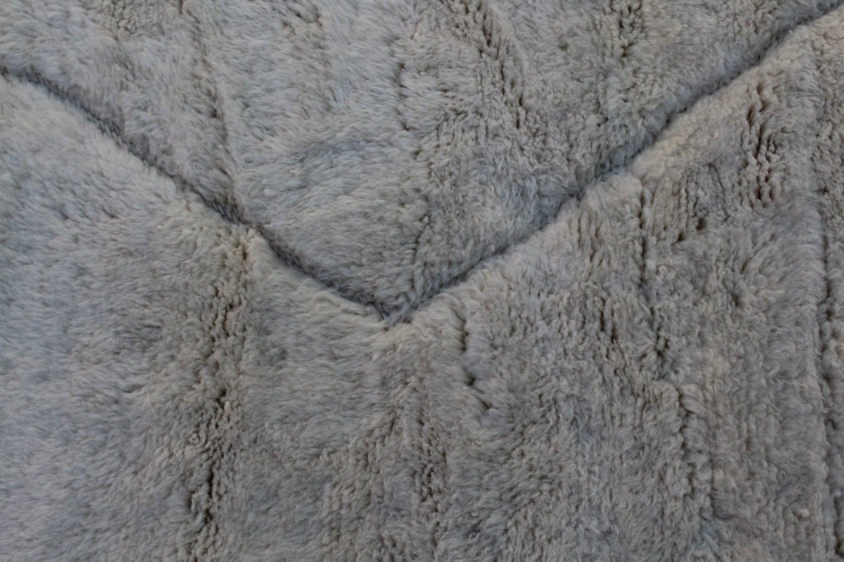 Close-up detail of off-white rug revealing its textured surface.