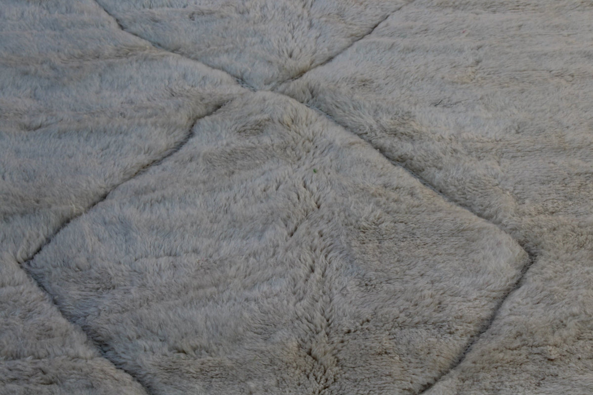 Close-up detail of off-white rug featuring a chevron pattern.