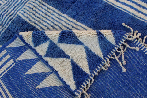 Close-up detail of a blue and white rug showcasing a geometric pattern.