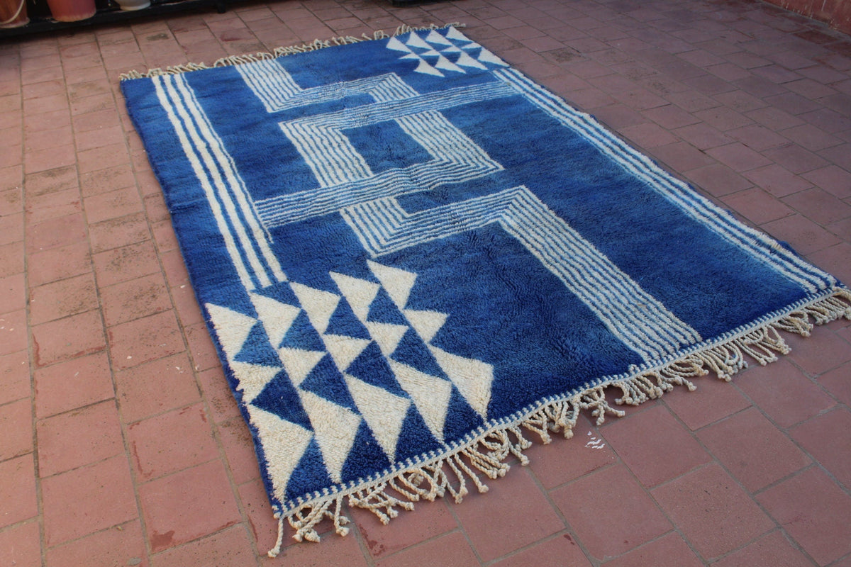 Close-up detail of a blue and white rug with a triangular design.