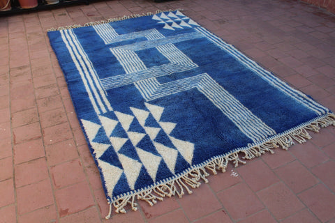 Close-up detail of a blue and white rug with a triangular design.