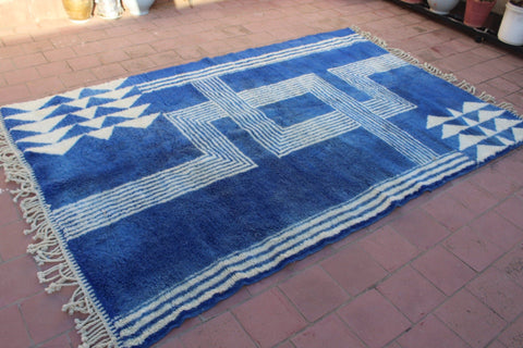 Detail close-up showing fringe edges of a blue and white rug.