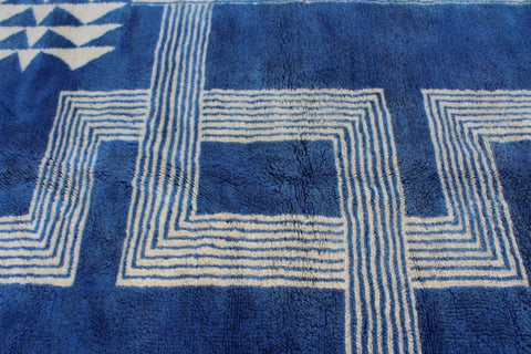 Detail shot of a blue and white rug with a geometric pattern.