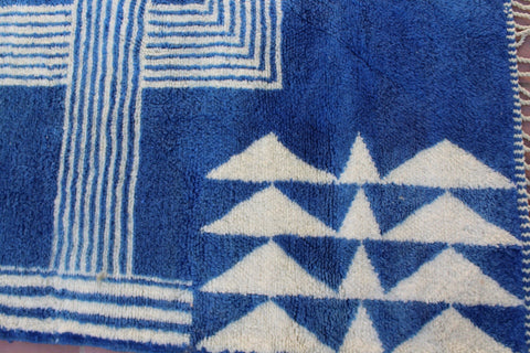 Detail shot of a blue and white rug showcasing a geometric pattern.