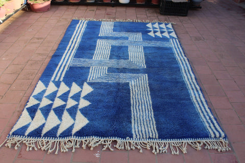 Close-up detail of a blue and white rug featuring a geometric pattern.