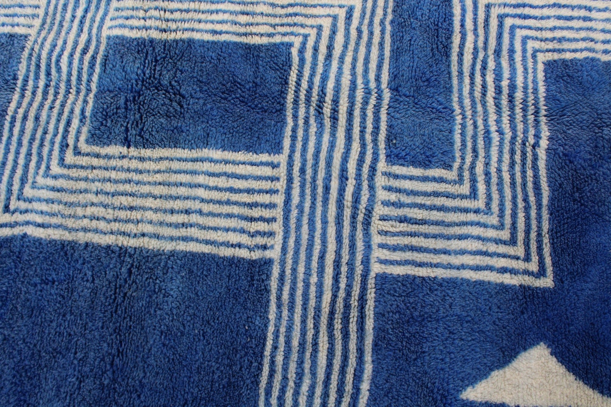 Close-up detail of a blue and white rug featuring a geometric pattern.