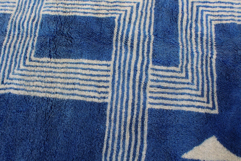 Close-up detail of a blue and white rug featuring a geometric pattern.